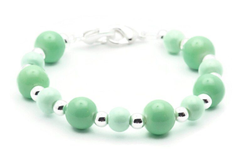 May include: A green and silver beaded bracelet with a silver clasp.