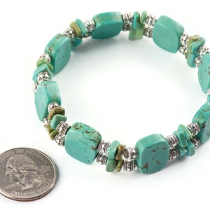 Op de afbeelding: Een turquoise en zilveren armband met vierkante turquoise kralen en zilveren spacer kralen. De armband is ongeveer zo groot als een Nederlandse euro.