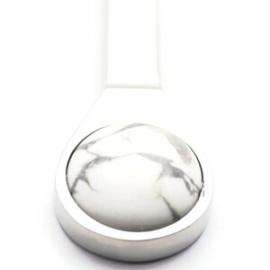 May include: A silver pendant featuring a white and grey marbled stone inlay.