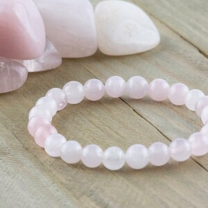 May include: A pink rose quartz bracelet with round beads. The bracelet is made of natural stones and is a popular choice for jewelry.