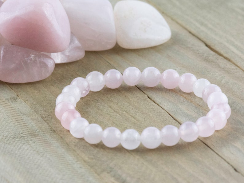 May include: A pink rose quartz bracelet with round beads. The bracelet is made of natural stones and is a popular choice for jewelry.