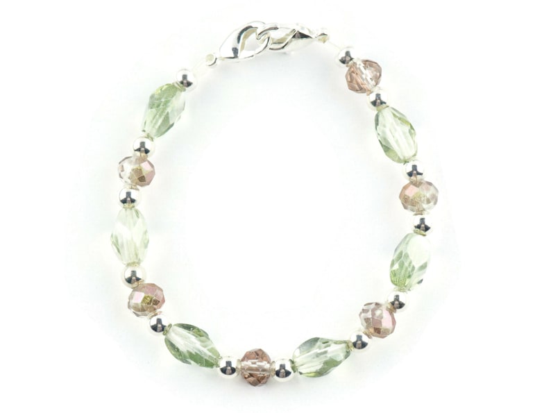 May include: A silver bracelet with green and brown crystal beads.