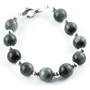 May include: A bracelet made of dark gray gemstone beads with silver spacers. The bracelet has a silver clasp.