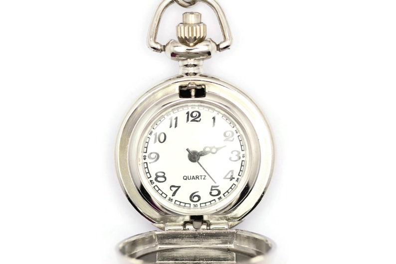 Op de afbeelding: Een zilveren zakhorloge met een witte wijzerplaat en zwarte cijfers. Het horloge is open en de wijzers staan op 10:10. Het horloge heeft een quartz uurwerk.