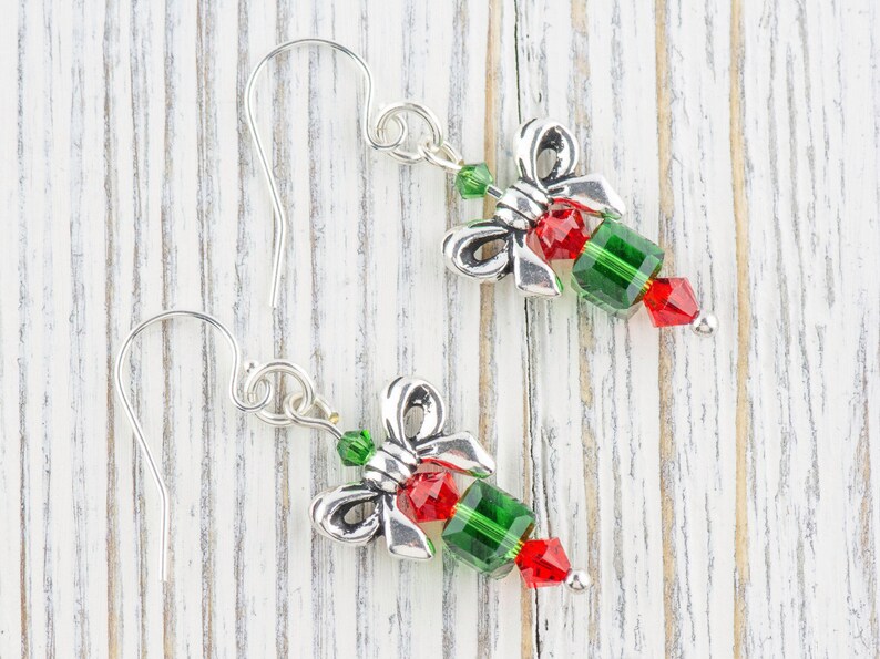 Pode incluir: Brincos de prata com um design de la&ccedil;o de cristal verde e vermelho.