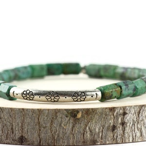 African Turquoise Stretch Bracelet displayed on a wood piece with tree bark edging