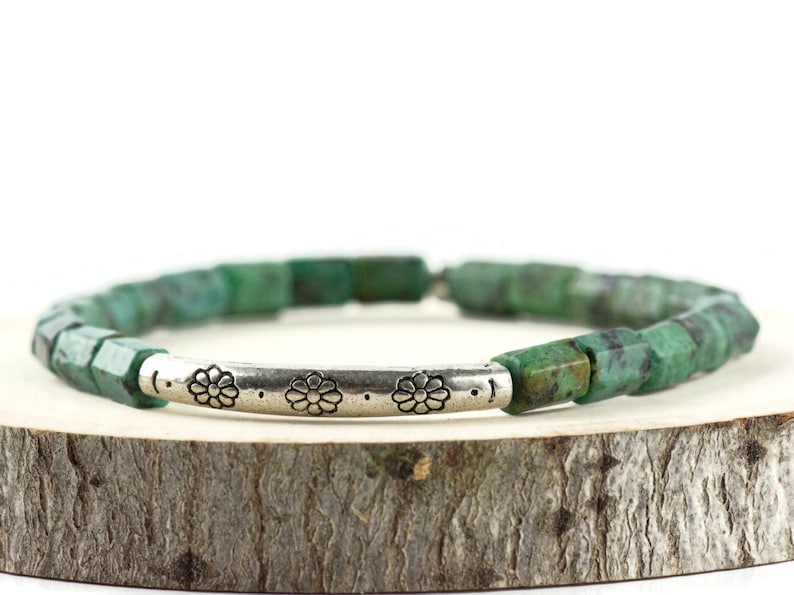 African Turquoise Stretch Bracelet displayed on a wood piece with tree bark edging