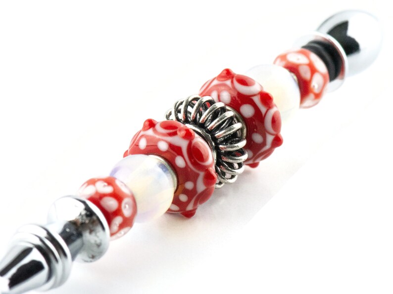 Peut inclure: Un bracelet de charme perl&eacute; argent&eacute; et rouge avec une perle d'espacement argent&eacute;e. Les perles sont rouges avec des pois blancs.