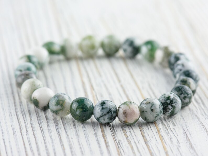 May include: A green and white agate stone bracelet with round beads. The bracelet is made of natural stones and is a beautiful and unique piece of jewelry.