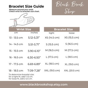 May include: A chart showing bracelet size guide in inches and centimeters. The chart shows the wrist size in centimeters and inches, and the corresponding bracelet size in centimeters for a tight and loose fit. The chart also includes instructions on how to determine the correct bracelet size.