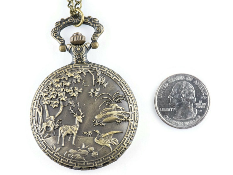 Pu&ograve; includere: Un orologio da tasca in bronzo con una catena, che presenta un design inciso di un cervo, un uccello e un albero. L'orologio &egrave; circa delle dimensioni di una moneta da 25 centesimi.