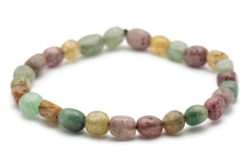 May include: A bracelet made of green, brown, and pink oval-shaped beads.