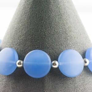 Peut inclure: Un bracelet bleu clair compos&eacute; de perles rondes en verre givr&eacute; s&eacute;par&eacute;es par des perles d'espacement argent&eacute;es.