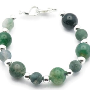 May include: A green agate and silver bead bracelet. The bracelet has a heart-shaped clasp.