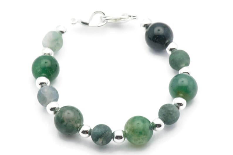 May include: A green agate and silver bead bracelet. The bracelet has a heart-shaped clasp.