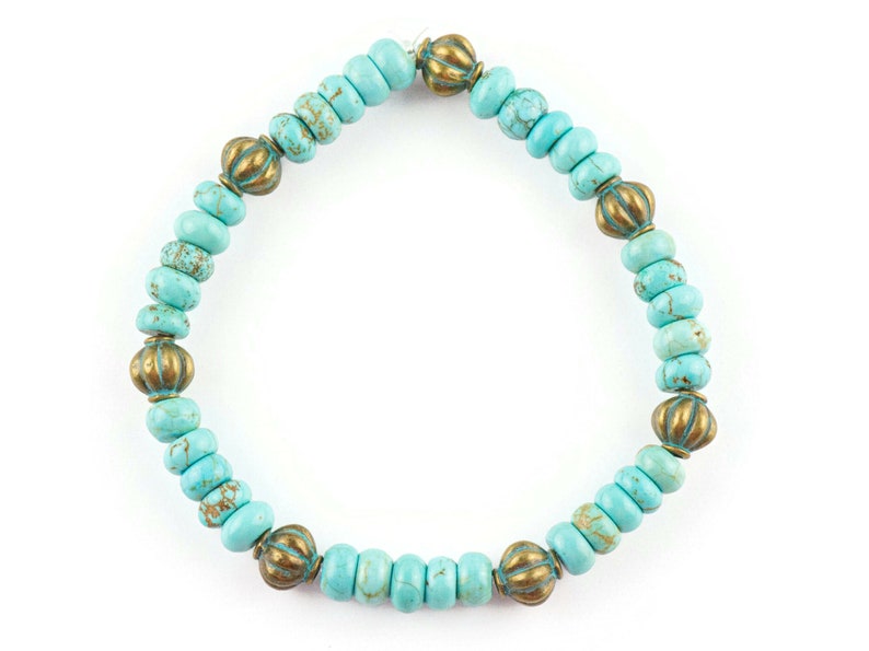 May include: Turquoise and gold beaded bracelet with a decorative design. The bracelet is made of small, round beads with a turquoise colour and gold accents.