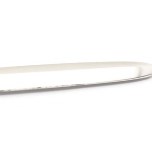 May include: A silver butter knife with a rounded tip and a smooth, polished surface.