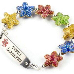 Puede incluir: Una pulsera colorida con una etiqueta de alerta m&eacute;dica que dice "TYPE I DIABETES". La pulsera tiene una cadena plateada con un s&iacute;mbolo m&eacute;dico rojo y una serie de abalorios de estrella de mar de colores.