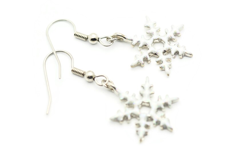 May include: A pair of silver snowflake dangle earrings. The earrings have a simple hook closure and a silver snowflake charm.