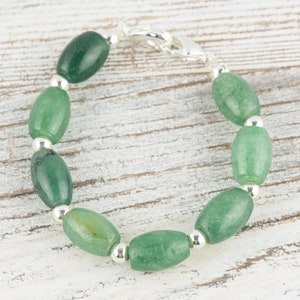 May include: A green jade stone bracelet with silver beads and a silver clasp.