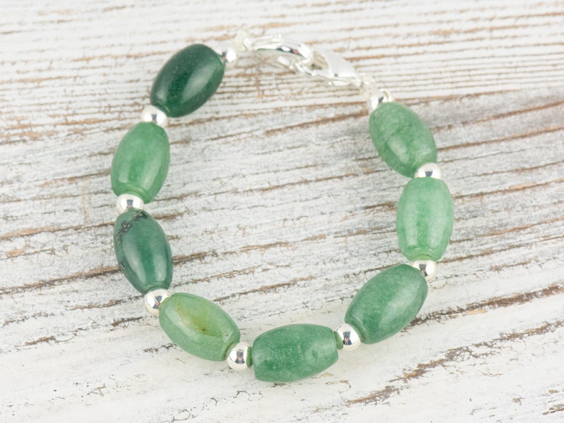 May include: A green jade stone bracelet with silver beads and a silver clasp.