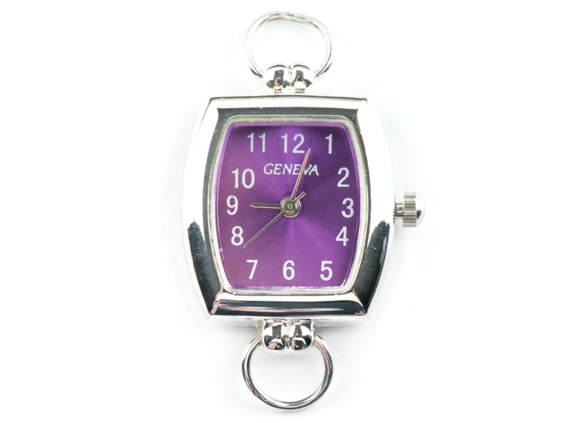 May include: A silver watch with a purple face and white numbers. The watch has a rectangular shape and a Geneva logo on the face.