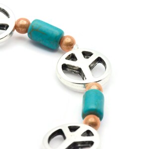 May include: A silver peace sign charm bracelet with turquoise and copper beads.