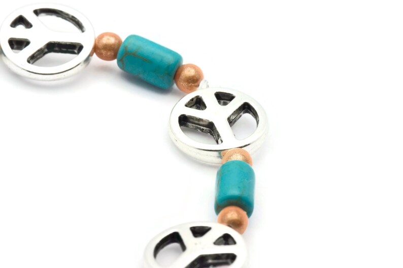 May include: A silver peace sign charm bracelet with turquoise and copper beads.