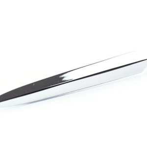 May include: A shiny, chrome-plated letter opener with a sharp, pointed blade. The opener has a sleek, modern design and a polished finish, reflecting the light. The handle is rounded and has a decorative design.