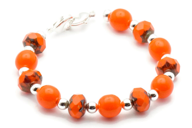 May include: Orange and black glass bead bracelet with a silver clasp.