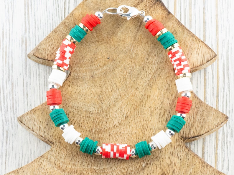 May include: A Christmas-themed bracelet with red, white, and green beads. The bracelet has a silver clasp.