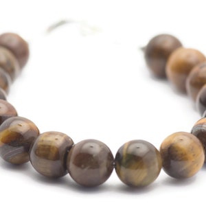 Op de afbeelding: Een bruine tijgeroog-armband met ronde kralen.