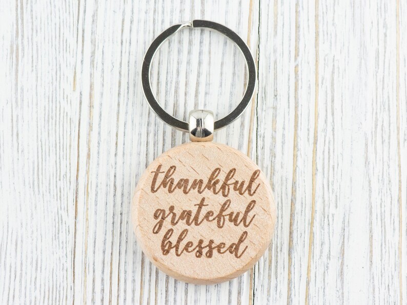 May include: Wooden keychain with a silver ring and the words "thankful grateful blessed" engraved on the front.