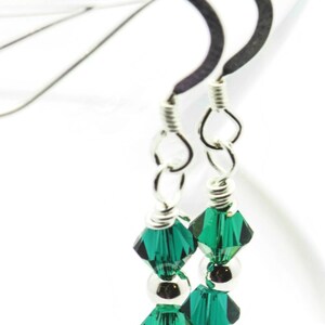 May Emerald Swarovski Crystal Birth Month Sterling Silver Drop Earrings hanging on vase