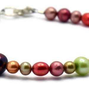 Pu&ograve; includere: Un braccialetto di perle multicolori con una chiusura argentata. Le perle sono in tonalit&agrave; di rosa, rosso, arancio, giallo e verde.