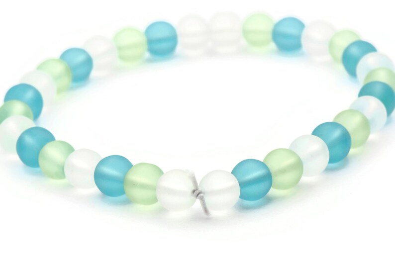 May include: A bracelet made of frosted glass beads in shades of blue, green, and white.