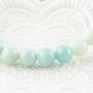May include: A bracelet made of light blue and white round beads. The beads are smooth and polished.