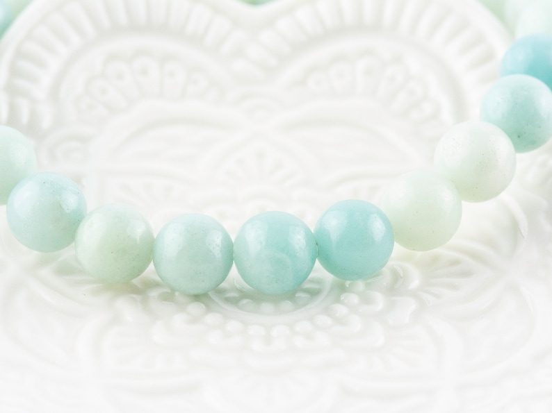 May include: A bracelet made of light blue and white round beads. The beads are smooth and polished.