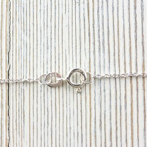 K&ouml;nnte beinhalten: Eine silberne Kettenkette mit einem Karabinerverschluss. Der Verschluss ist mit der Nummer "925" gekennzeichnet, was bedeutet, dass die Kette aus Sterlingsilber besteht.