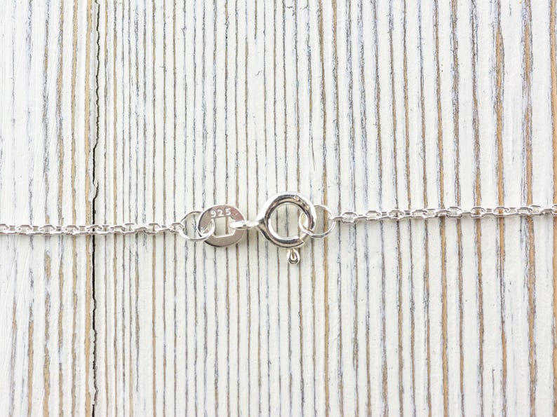 K&ouml;nnte beinhalten: Eine silberne Kettenkette mit einem Karabinerverschluss. Der Verschluss ist mit der Nummer "925" gekennzeichnet, was bedeutet, dass die Kette aus Sterlingsilber besteht.