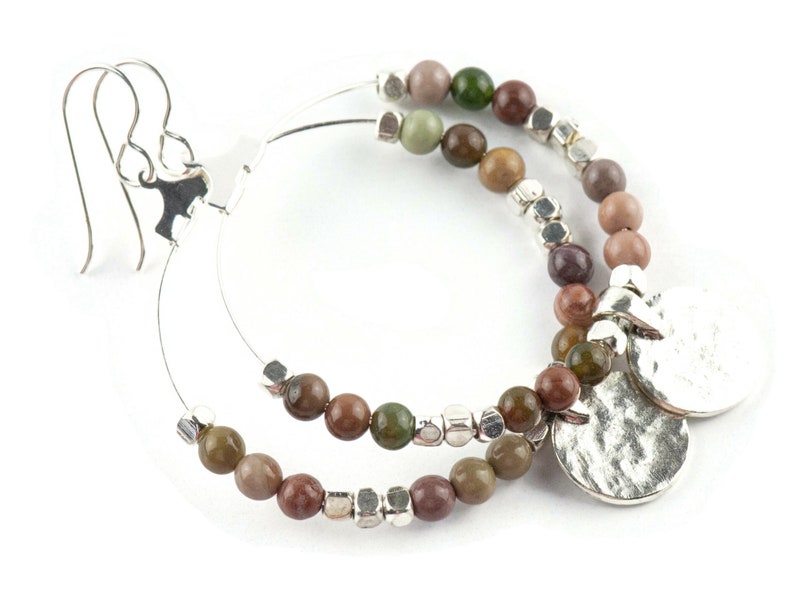May include: Silver hoop earrings with a double row of brown, green, and gray gemstone beads and two silver charm pendants.