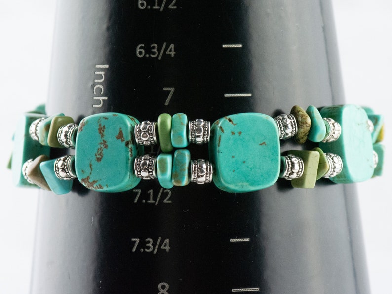 Op de afbeelding: Turquoise en zilveren kralen armband met vierkante turquoise kralen en zilveren spacer kralen. De armband is 17,78 cm lang.