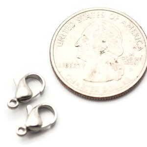 May include: Two silver-toned lobster claw clasps, each about the size of a US quarter.