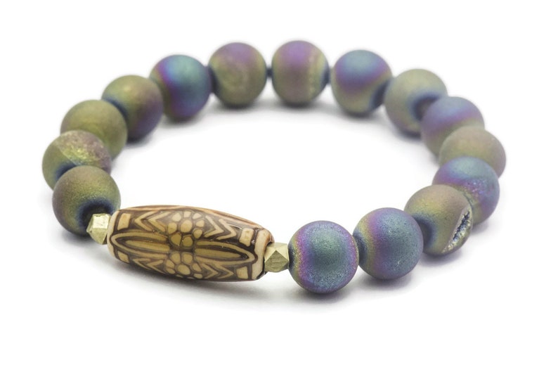 May include: A bracelet made of iridescent agate beads with a brown and white patterned bead in the center.