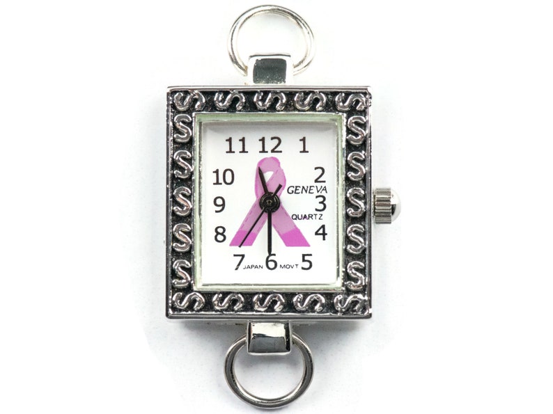 Op de afbeelding: Een vierkant Geneva quartz horloge met een zilverkleurig frame en een witte wijzerplaat. De wijzerplaat heeft zwarte cijfers, een roze lint en de woorden "GENEVA QUARTZ". Het horloge heeft een zilverkleurige lus aan de boven- en onderkant.
