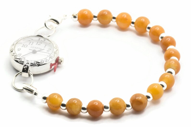 May include: A silver watch with a white face and black Roman numeral markings. The watch is attached to a bracelet made of orange beads and silver spacers.