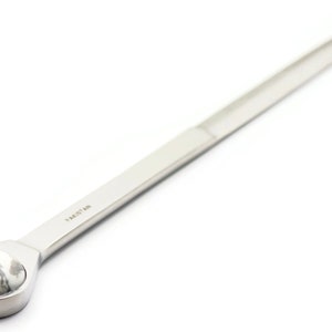 May include: A silver letter opener with a white marble handle. The handle is round and has a smooth surface. The letter opener is approximately 25 cm long.