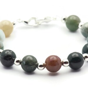 Pode incluir: Um bracelete feito de contas de &aacute;gata verde, marrom e branca com espa&ccedil;adores de prata.