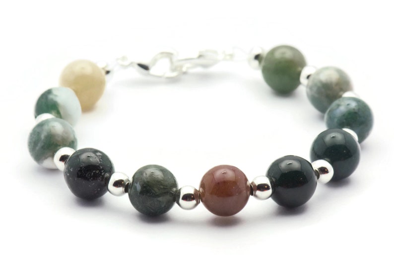 Pode incluir: Um bracelete feito de contas de &aacute;gata verde, marrom e branca com espa&ccedil;adores de prata.
