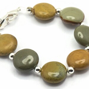 May include: A bracelet made with round, multi-colored, polished stones and silver beads.